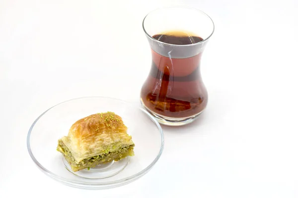 Баклава с фисташками и турецкой чашкой чая на белом фоне — стоковое фото