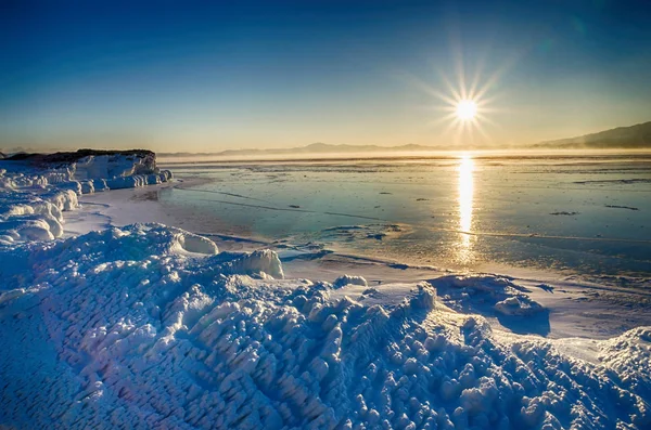 Témpanos de hielo flotando en el agua de niebla en el lago Baikal y la colina. Puesta de sol —  Fotos de Stock