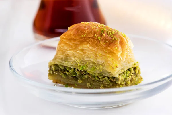 Baklava con pistacho y taza de té turco sobre un fondo blanco — Foto de Stock