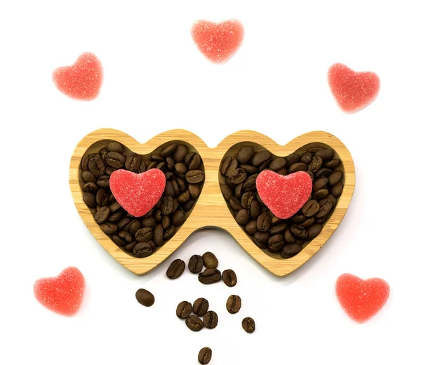 Piatto di legno con caramelle di cuore durante il Giorno di S. Valentino e chicchi di caffè, vista dall'alto — Foto Stock