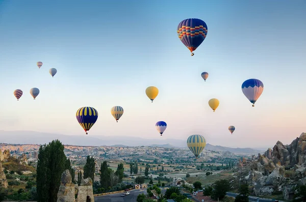 Globo de aire caliente volando sobre el paisaje rocoso en Capadocia Turquía — Foto de Stock