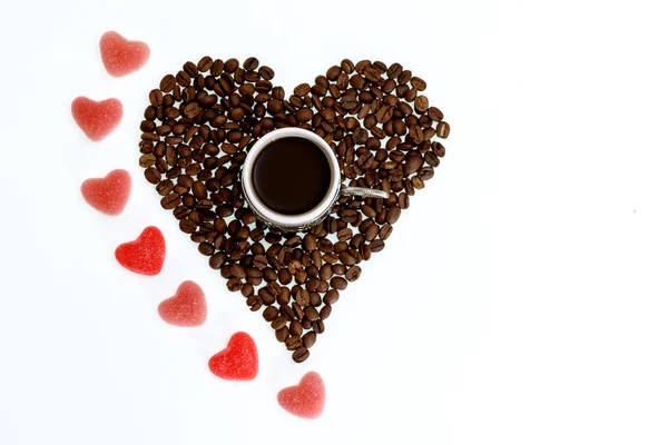 coffee beans heart with candies and cup for St. Valentines Day, top view