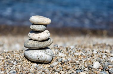 Piramit renkli çakıl. Rock Zen deniz arka planda. Uyum ve denge kavramı.