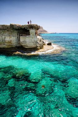 Sea caves of Cavo greco cape. Ayia napa, Cyprus with men clipart