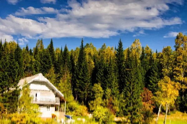 Leuchtende Orange-, Gelb- und Grüntöne mit Haus spiegeln sich im Wasser an einem frühen Morgen im Herbst — Stockfoto