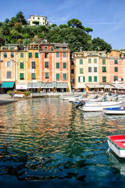 İtalya, Portofino - 3 Ekim 2014: Portofino 'nun pitoresk körfezinde renkli evlerin manzaralı tekneler