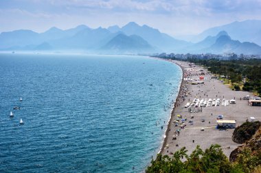 Antalya, Türkiye - 26 Temmuz 2019: Güneşli yaz gününde Konyaalti kumsalı ve Taurus dağları, Türkiye Akdeniz kıyıları