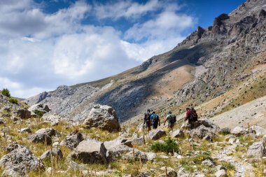Türkiye, Chamard - 3 Ağustos 2019: Turistler yaz günü Türk Milli Parkı aladagında dağ manzarası boyunca yürüyorlar, arkadan bakıyorlar