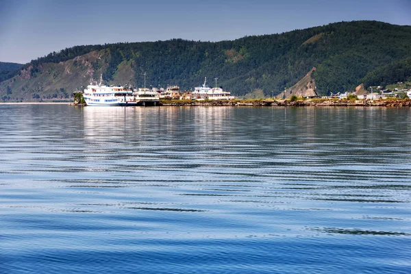 Λίμνη Baikal κοντά στο χωριό Port Baikal, Ρωσία. Οριζόντια άποψη ημέρας της υψηλής ακτής, πράσινο δάσος, σπίτια, πλοία, καθαρά νερά της λίμνης — Φωτογραφία Αρχείου