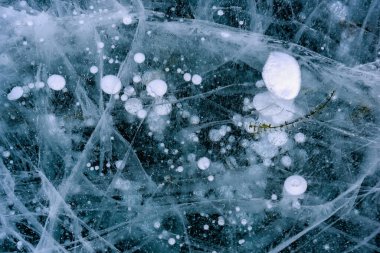 Baykal Gölü 'nün güzel buzu soyut çatlaklar ve derin yeşil bitkilerle