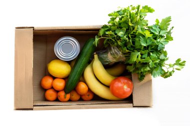 Yiyecek, meyve, sebze ve maydanoz dolu bir bağış kutusu. İzole edilmiş arkaplan ile tepeden görüntüle