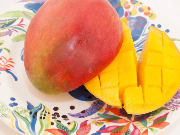 Dojrzałe mango z plastrami na talerzu — Zdjęcie stockowe