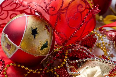 Beyaz arka planda kırmızı kurdeleli Noel süslemeleri.