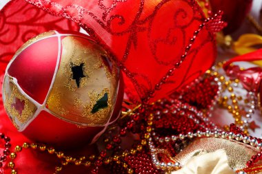 Beyaz arka planda kırmızı kurdeleli Noel süslemeleri.