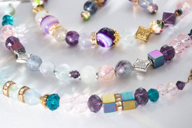 Beyaz B 'de yarı değerli ve kristal altın bilezikler.