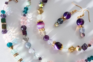 Beyaz B 'de yarı değerli ve kristal altın bilezikler.