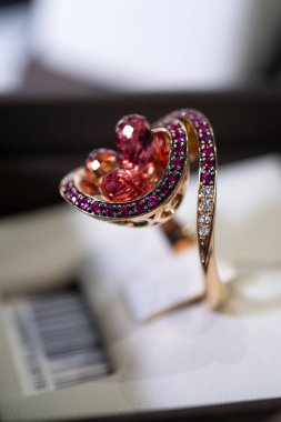 Mücevher mağazası vitrininde değerli taşlarla beyaz altın yüzük sergileniyor. Kocaman turmalin ve elmaslarla dolu bir yüzük. Kapat.