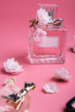 Kozmetik ürünleri ve pembe arka planda çiçekleri olan bayan.. 
