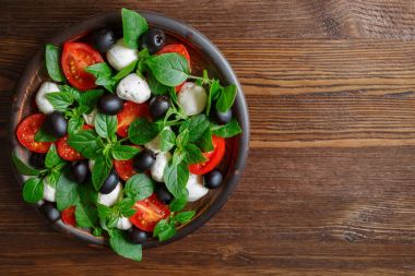 Caprese with mozzarella, tomatoes, basil and olives. Classic Italian salad. clipart