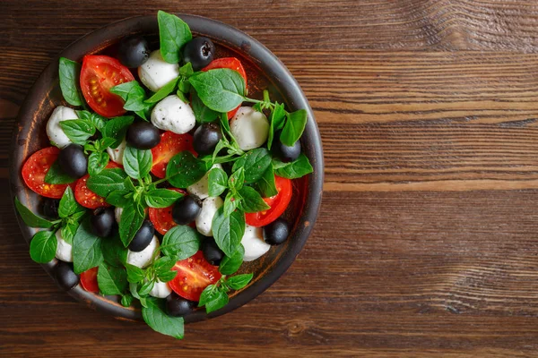 Caprese Mozzarella peyniri, domates, fesleğen ve zeytin. Klasik İtalyan salatası.