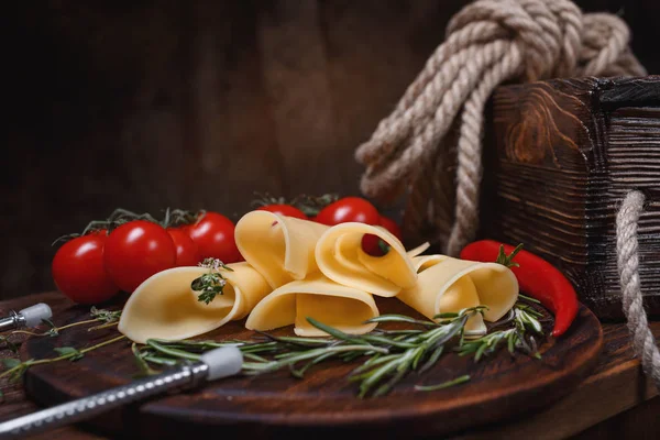 Rolos de queijo em uma tábua de madeira . — Fotografia de Stock