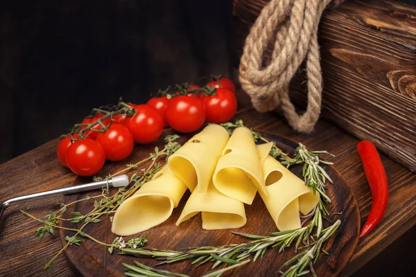 Rolos de queijo em uma tábua de madeira . — Fotografia de Stock