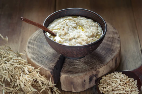 Tereyağı bir kil kase ile yulaf lapası.