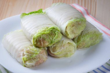 Beyaz bir tabağa çiğ lahana rulo. 