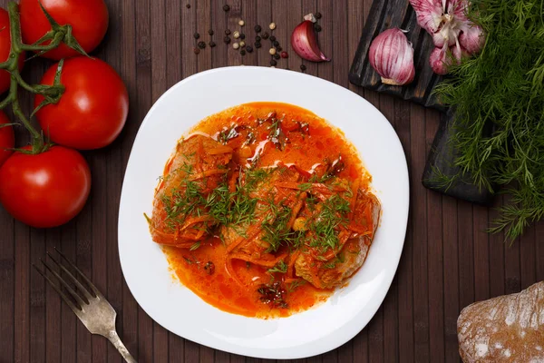 Lahana domates sos içinde beyaz bir plaka üzerinde rulo.. 