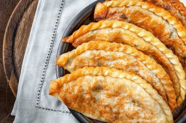 Lahana ve Yeşil Kil tabağa keten peçete üzerinde kızarmış pies. Yakın çekim, üstten görünüm.