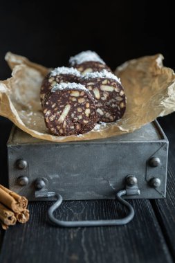 Hindistan cevizi serpilmiş vejetaryen çikolatalı salam ve dilimler halinde parşömen dilimleri.. 