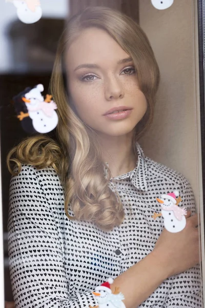Bonito sardas menina atrás janela — Fotografia de Stock