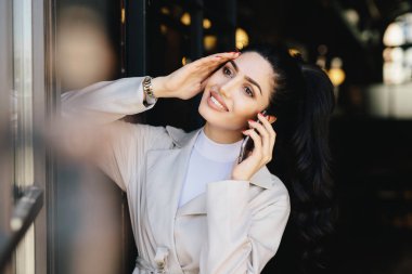 Kapalı duran ise cep telefonu iletişim görünüm çekici çok esmer kadın narin ellerle. Genç esmer işkadını dinlenme telefon kullanarak erkek arkadaşıyla konuşuyor