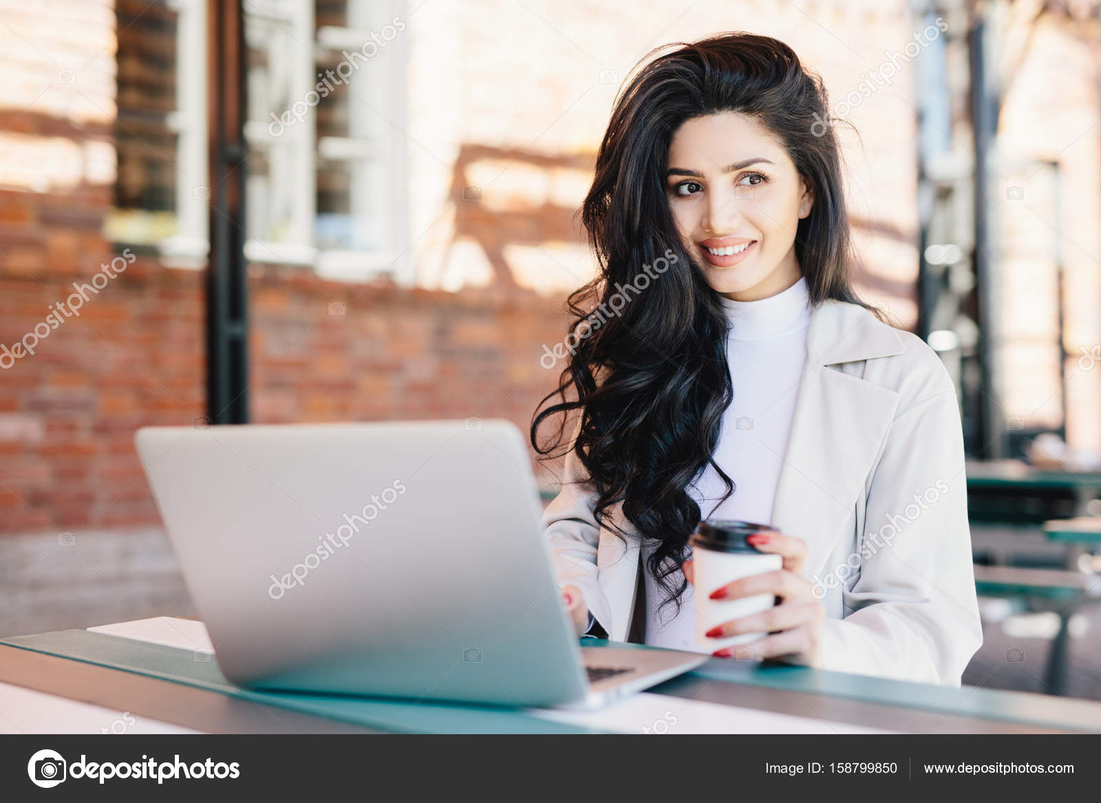 Smiling Female Student With Dark Wavy Hair Reading News On Her