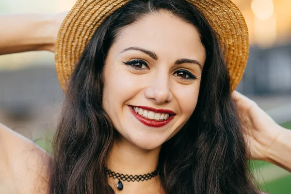 Koyu saçlı, sevimli erkek büyüleyici gözleri ve iyi bir ruh hali duygu gevşeme saman yaz şapka giyen hoş gülümseme portresi kapatın. Güzel görünümü ile çekici kadın modeli