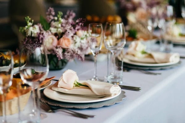 Tabell serveras för speciella tillfällen. Tom tallrik, Glasögon, gafflar, servetter och blommor på bord med vita dukar. Eleganta middagsbordet. Vit dukning — Stockfoto