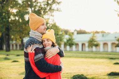 İnsanlar ve yakınlık kavramı. Aşık genç çift tarihi, birbirinize sarılın, hisset park, yalnız kalmaktan desteği mükemmel ilişkileri var. Sıcak kazak ve şapka hugs kız yakışıklı adam