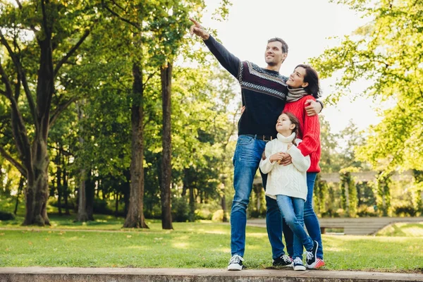 Obrazu szczęśliwy radosny młody ojciec rodziny, matki i trochę córka grać razem w jesienny park, krajobrazy, przyroda poza. Atrakcyjny mężczyzna pokazuje coś z ręki córka i żona — Zdjęcie stockowe