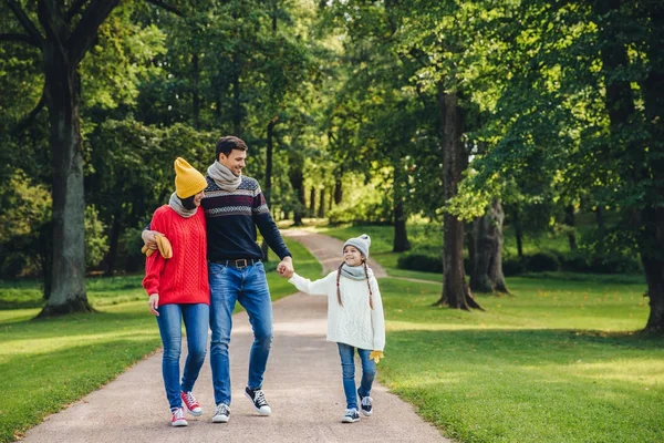 Os pais felizes se sentem orgulhosos de sua pequena filha bonita, caminham juntos no parque, desfrutam do clima de outono. A família tem descanso durante os fins de semana em todo o parque verde ou floresta. Pais e infância — Fotografia de Stock