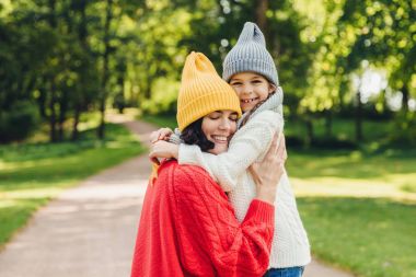 Sevgi iyi görünümlü genç anne tek kızını kucaklıyor, sıcak ilişki, çok akıllı için mutlu ve güzel bir kız var, birlikte oyun açık, birbirimizi çok iyi anlıyoruz
