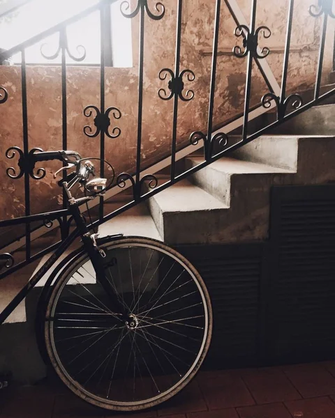 Bicicleta deportiva aparcada cerca de escaleras interiores. Bicicleta de carretera espera al anfitrión. Antiguas escaleras y transporte moderno. Estilo vintage. bicicleta deportiva profesional de alta velocidad . — Foto de Stock