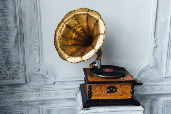 Old gramophone with horn speaker stands against anicent background, produces songs recorded on plate. Music and nostalgia concept. Gramophone with phonograph record — Stock Photo, Image