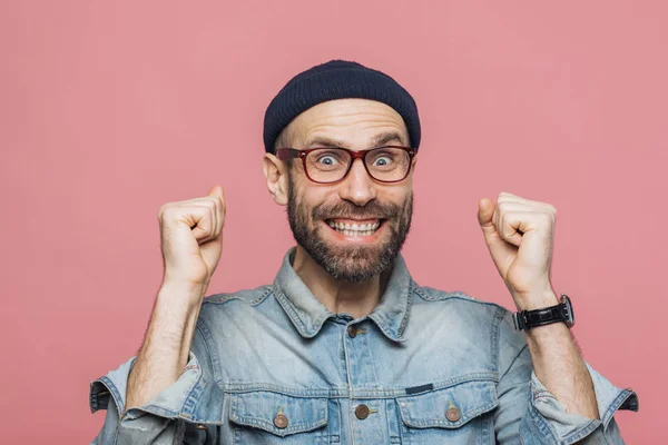 Hombre alegre con barba gruesa y bigote cierra los puños y mira — Foto de Stock