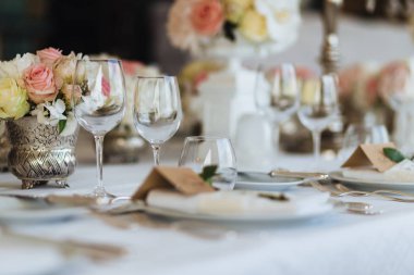 Güzel masa Züccaciye Mağazaları ve cultery, Festival olay için hazırlanmış çiçeklerle süslenmiş ile devam eder. Özel durum celebrted lüks restoran veya kafe. Tablo ayarı kavramı. Düğün masa