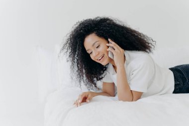 Kıvırcık saçlı, mutlu bir kadın hoş bir telefon konuşması yapar. Hafta sonu yatmadan önce arkadaşıyla konuşur. Beyaz tişört giyer, rahat bir yatakta uzanır.