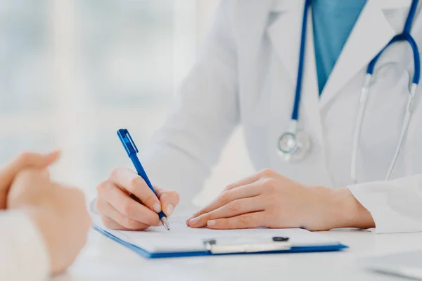 Tanımlanamayan kadın doktor panoya yazıyor, hasta için reçete yazıyor, analiz için veri kaydediyor, beyaz önlük giyiyor. Yaklaş, ellere odaklan. İlaç, sigorta, sağlık hizmeti kavramı