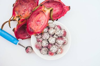 Pitahaya beyaz arka plan üzerinde topları hazırlanmış. Dilimlenmiş tropik meyve. Tatlı servisi. Oyulmuş meyve. Ejderha meyve topları. Parlak renkler. Sağlıklı beslenme kavramı