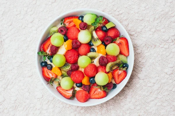 Salad buah segar yang sehat dalam mangkuk. Potongan stroberi, raspberry, kiwi, jeruk keprok, blueberry di piring. Buah yang lezat. Hidangan vegetarian. Ripe berry . — Stok Foto