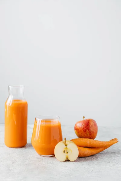 Plan vertical de jus de carotte d'orange naturel frais dans un bocal en verre, pomme mûre et carotte sur fond blanc. Boissons saines et désintoxication . — Photo