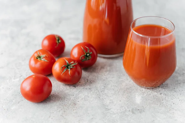 Abgeschnittenes Bild von Tomaten und Tomatensaft auf weißem Hintergrund. Ernährungs- und Ernährungskonzept. Erfrischungsgetränk. rotes frisches rohes Gemüse. — Stockfoto